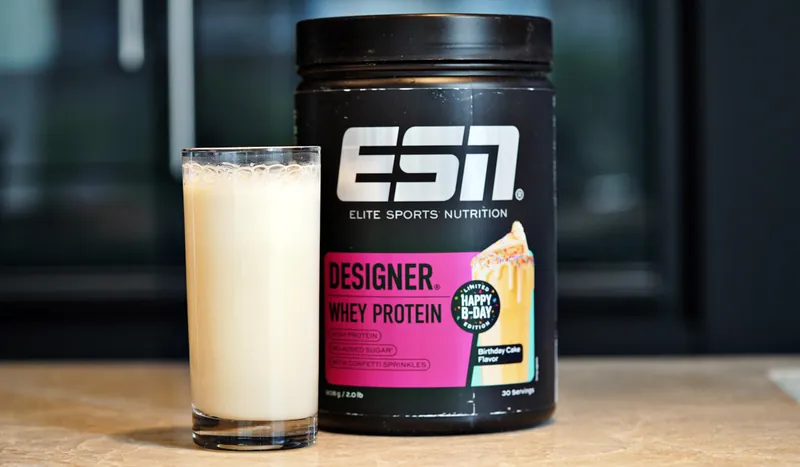 ESN Designer Whey Protein – Birthday Cake, with a glass